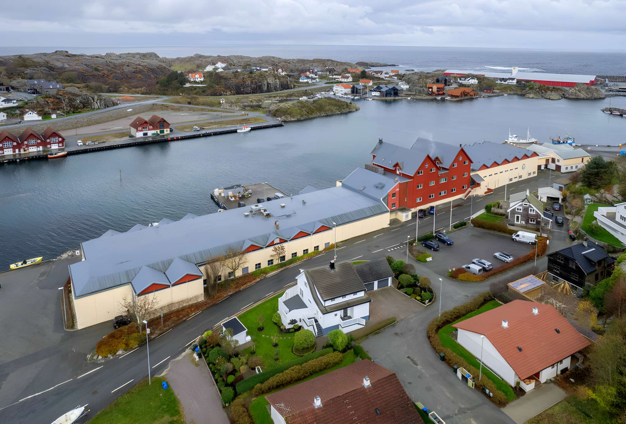 Flyfoto av Vågen 42 med kai, parkering og Sirevåg havn i bakgrunnen